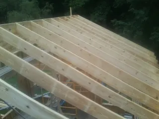 New roof rafters set over an addition before sheathing in Linden
